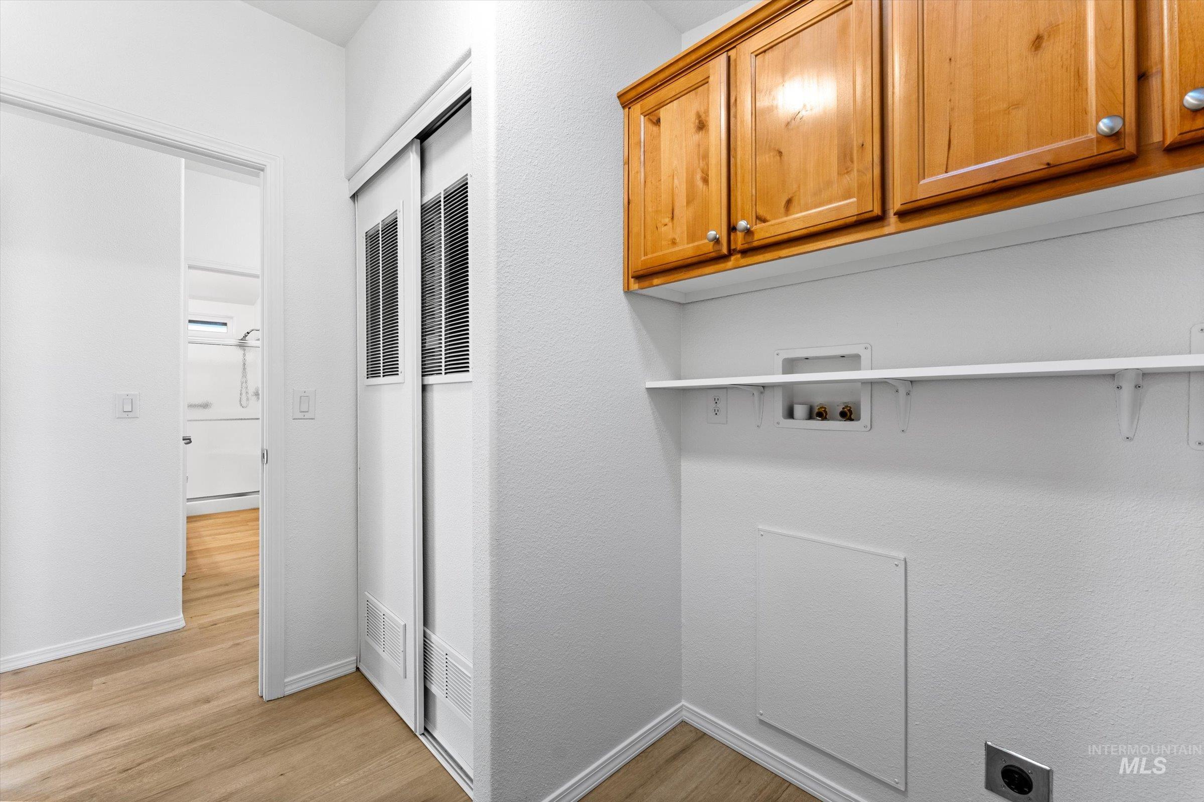 421 South Curtis Road, Unit 122 122 Boise, ID 83705 - Photo 20 of 24 Washroom featuring washer hookup, light wood-style floors, and cabinet space