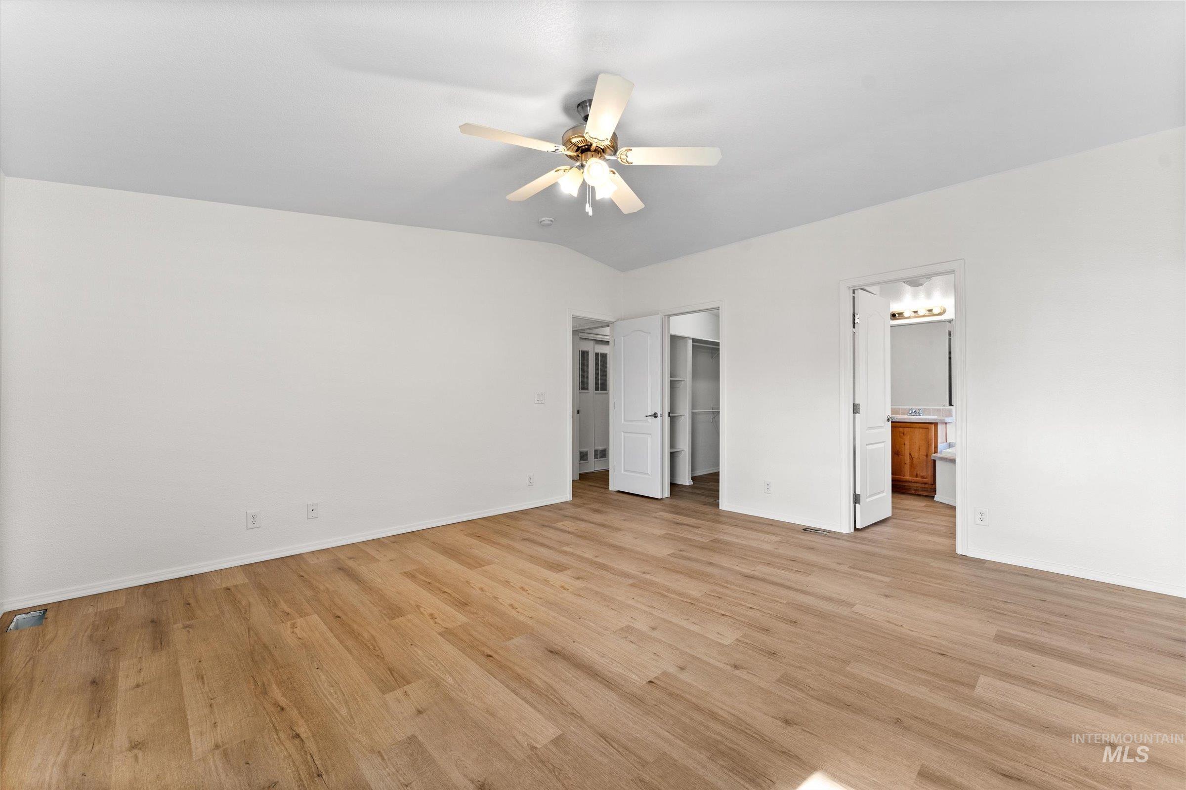 421 South Curtis Road, Unit 122 122 Boise, ID 83705 - Photo 8 of 24 Unfurnished bedroom with a walk in closet, ceiling fan, light wood finished floors, and connected bathroom