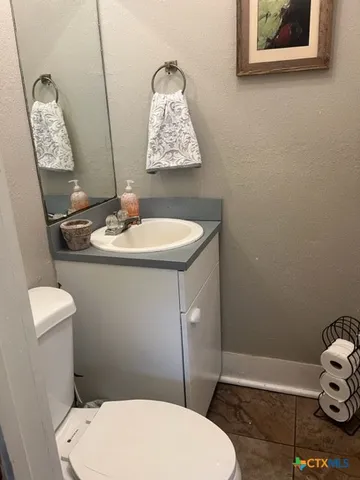 a bathroom with a toilet sink and mirror