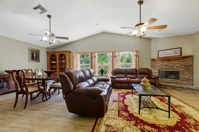 a living room with furniture a chandelier and a fireplace