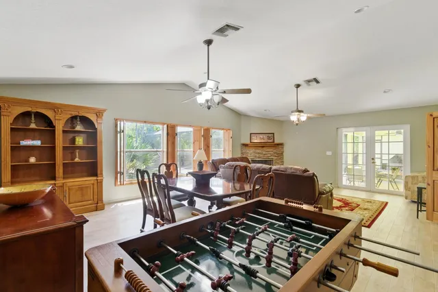 a kitchen with stainless steel appliances granite countertop a stove a sink dishwasher a dining table and chairs with wooden floor