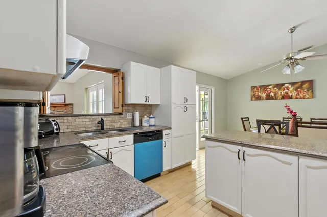 a kitchen with white cabinets and appliances