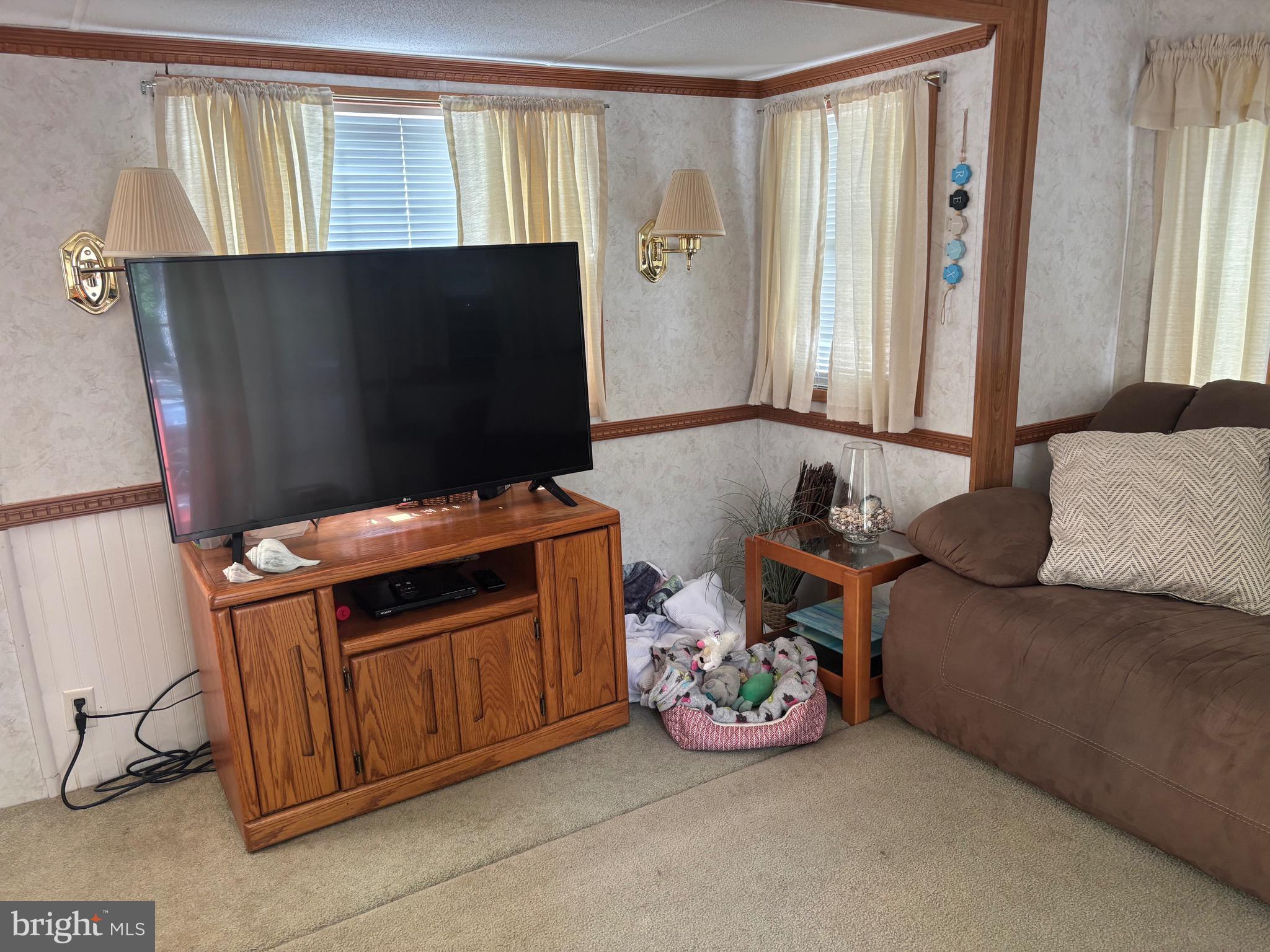 60 Corsons Tavern Road, Unit 248 Ocean View, NJ 08230 - Photo 13 of 18 a living room with a couch and a flat screen tv