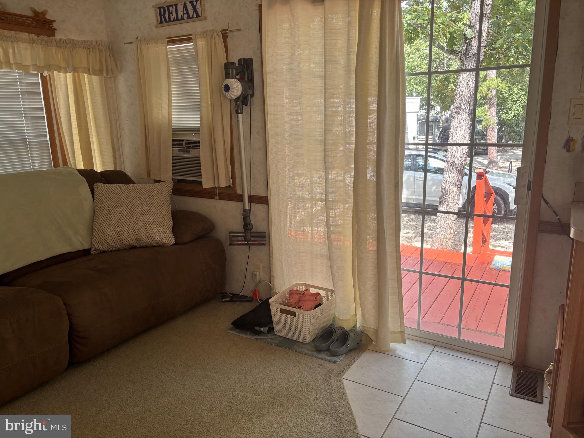 60 Corsons Tavern Road, Unit 248 Ocean View, NJ 08230 - Photo 14 of 18 a living room with furniture and a floor to ceiling window