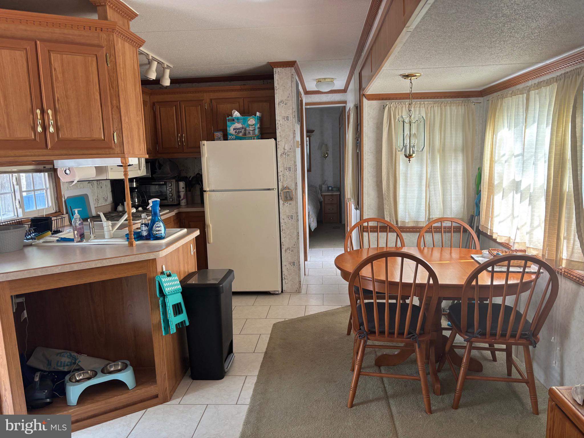 60 Corsons Tavern Road, Unit 248 Ocean View, NJ 08230 - Photo 9 of 18 a dining room with furniture a chandelier and kitchen view