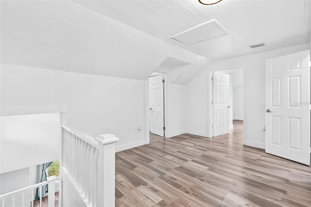 a view of empty room with wooden floor