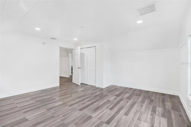a view of an empty room with wooden floor
