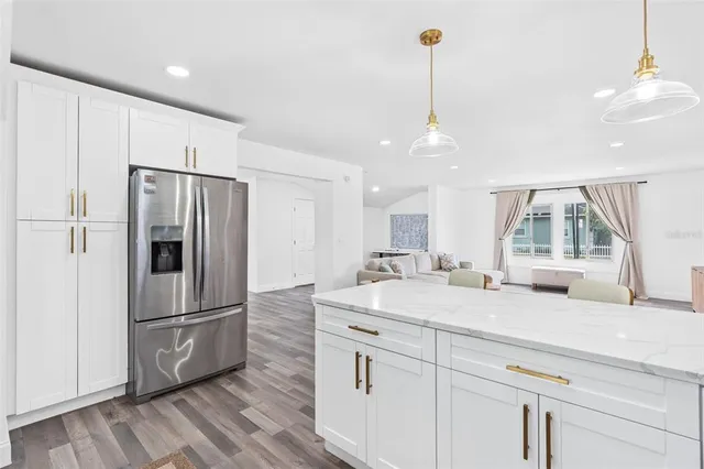 a kitchen with kitchen island white cabinets and stainless steel appliances