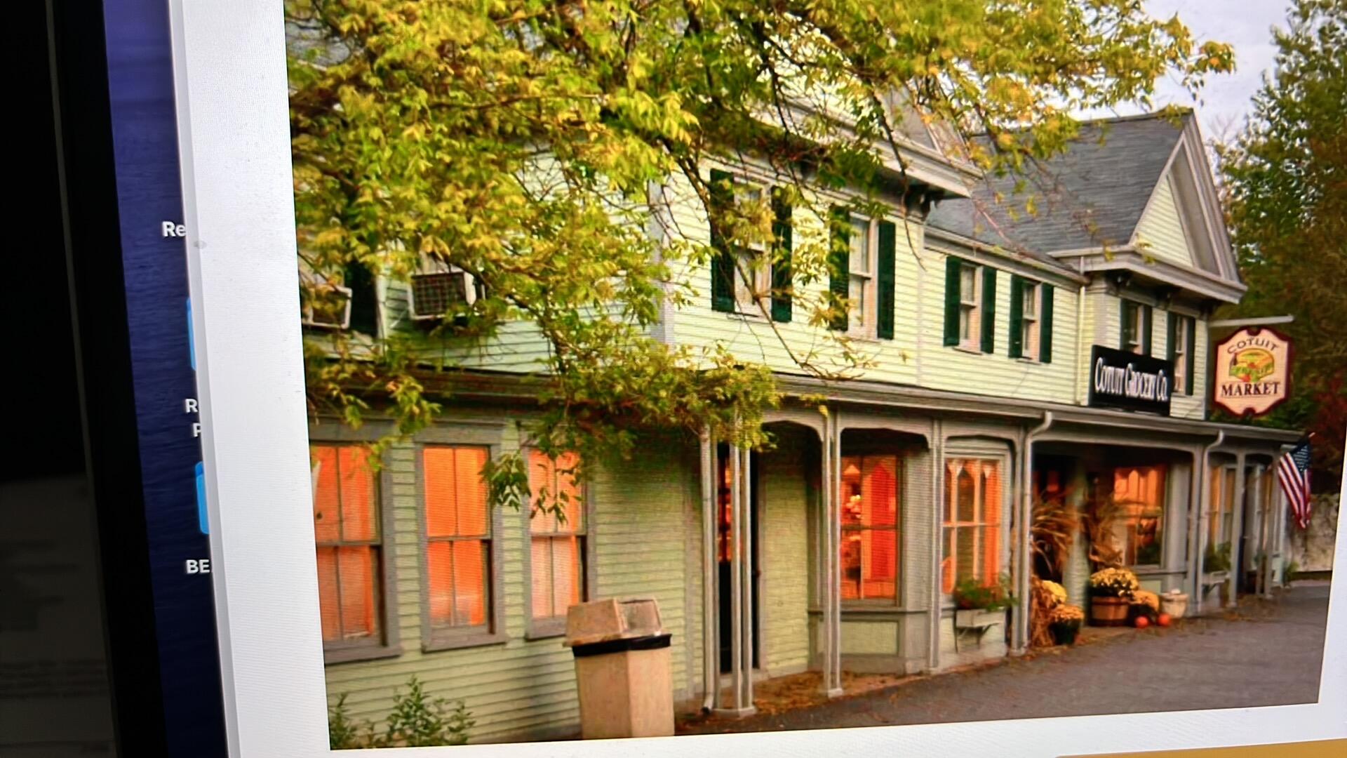 4701 Falmouth Road Cotuit, MA 02635 - Photo 37 of 39 a view of a brick house with large windows and a small yard