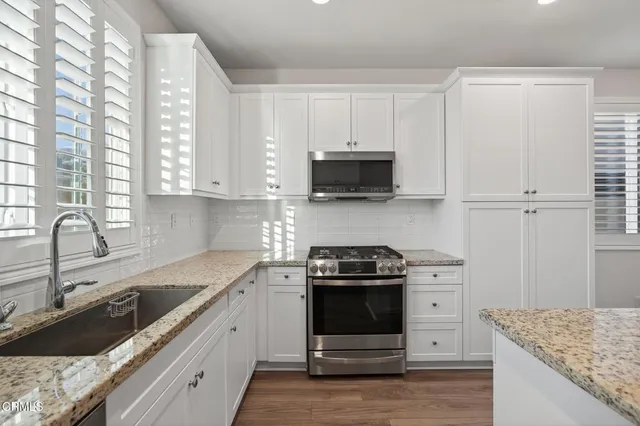a kitchen with a refrigerator a sink and wooden cabinets