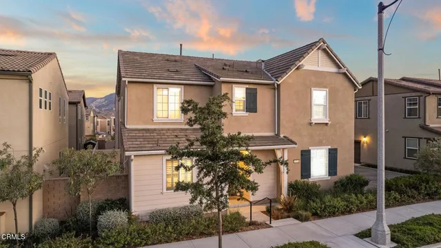 a front view of a house with a tree