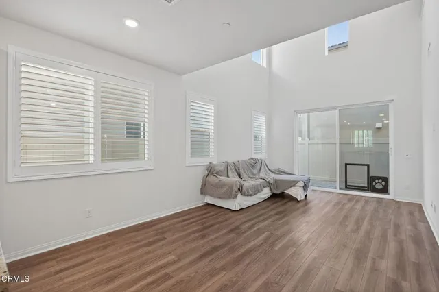 a kitchen with white cabinets and wooden floor