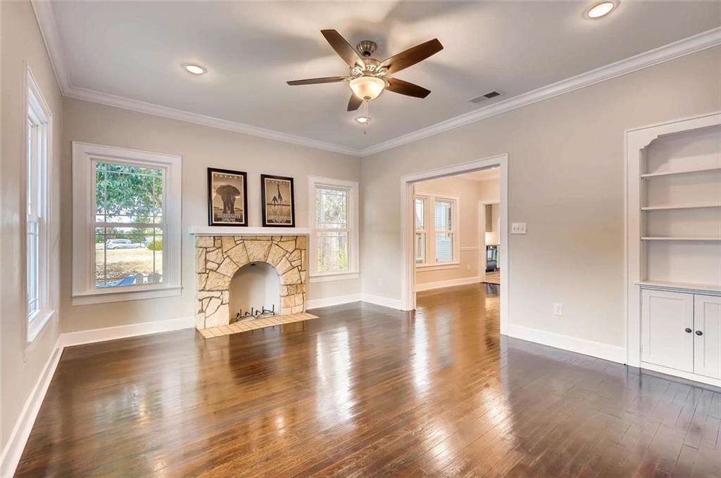 906 East 38th 1/2 Street Austin, TX 78751 - Photo 5 of 28 Original wood flooring in the living room, built in bookshelves and stone fireplace. The large windows let in loads of natural light.