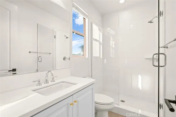 a bathroom with a double vanity sink large mirror and a bathtub