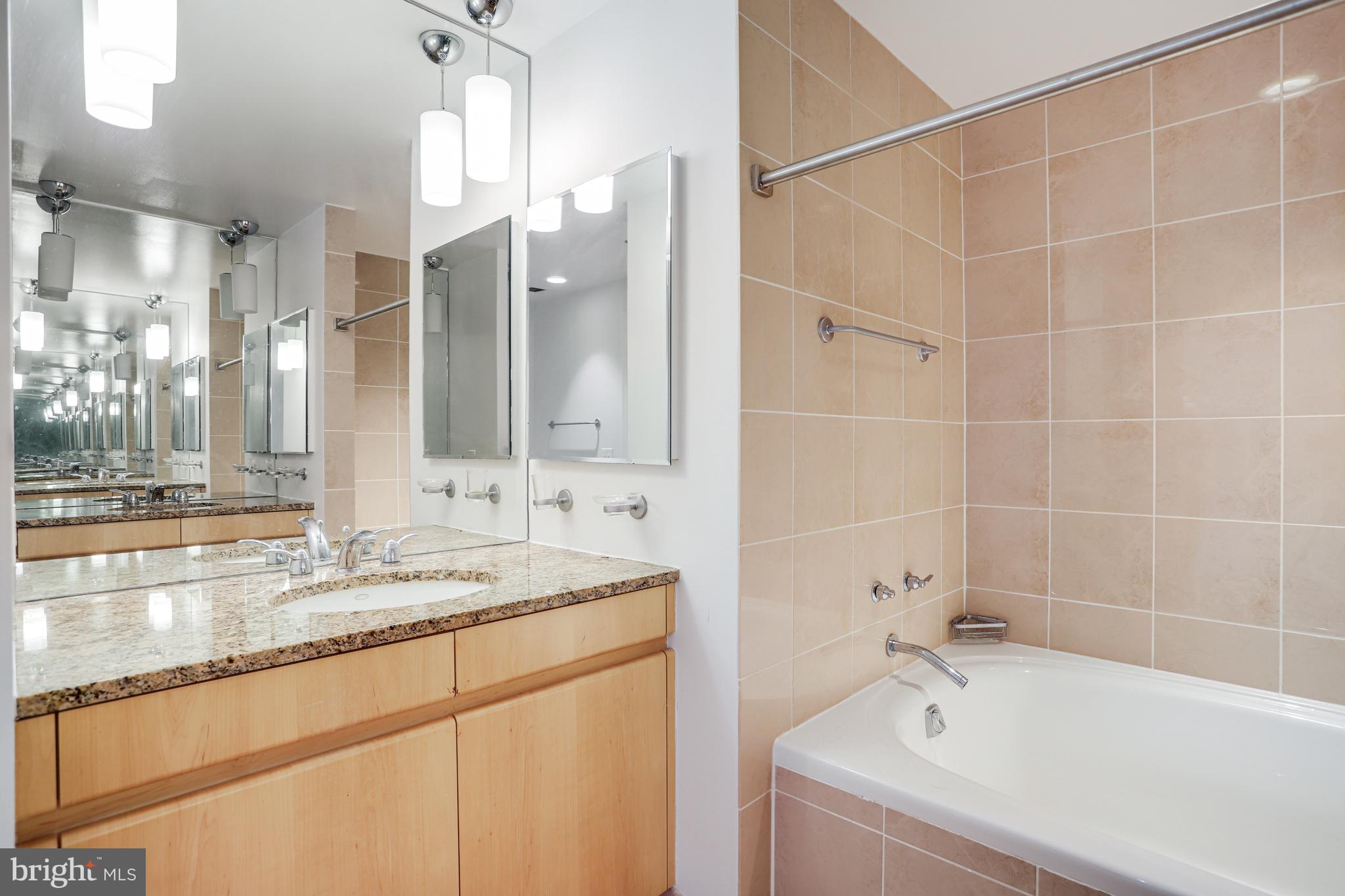 675 E Street Northwest, Unit 900 Washington, DC 20004 - Photo 11 of 40 a bathroom with a tub sink and mirror