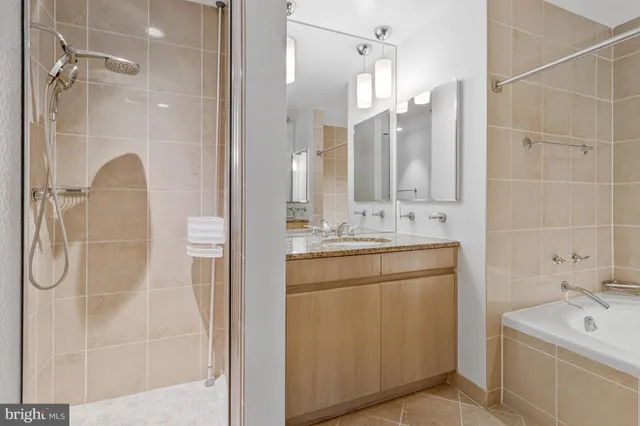 a bathroom with a double vanity sink mirror and shower