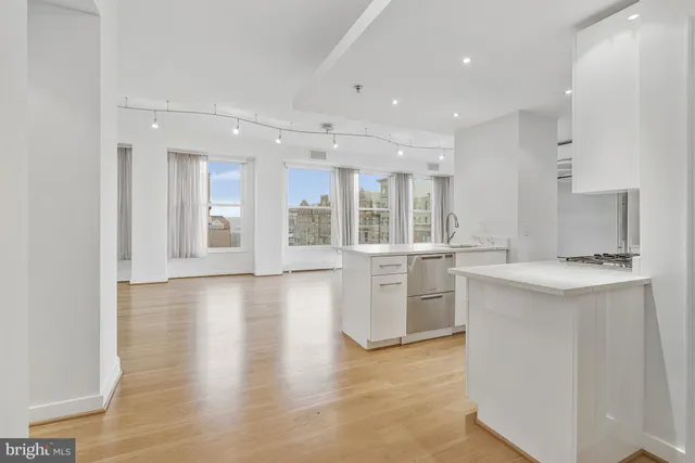 a large kitchen with stainless steel appliances a large counter top and a stove