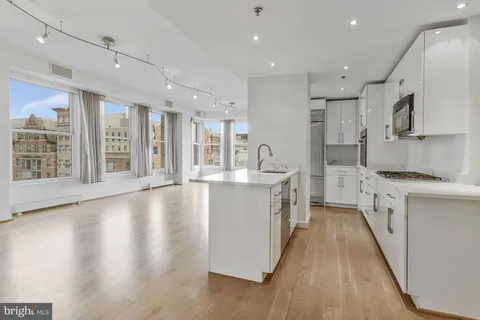 a large kitchen with stainless steel appliances granite countertop a large center island and a sink