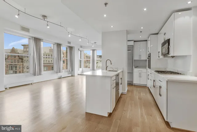a large kitchen with stainless steel appliances granite countertop a large center island and a sink