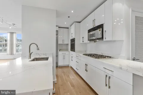 a kitchen with white cabinets and stainless steel appliances