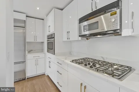a kitchen with stainless steel appliances granite countertop a stove and a microwave