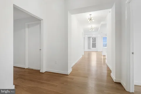 a view of a hallway with wooden floor