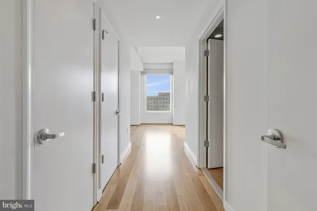 a view of a hallway with wooden floor and closet