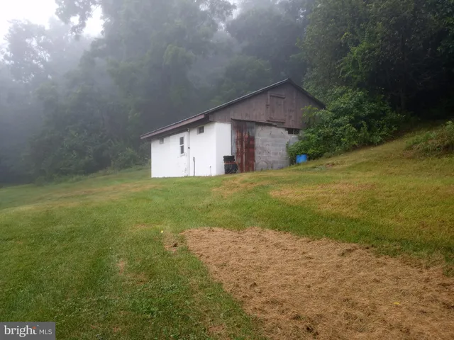a view of a wooden house with a small yard