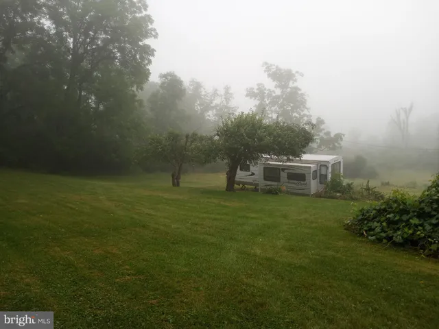 a backyard of a house with plants and wooden fence