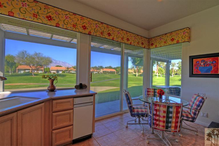41 Augusta Drive Rancho Mirage, CA 92270 - Photo 8 of 25 a view of a dining room with furniture a rug and a floor to ceiling window
