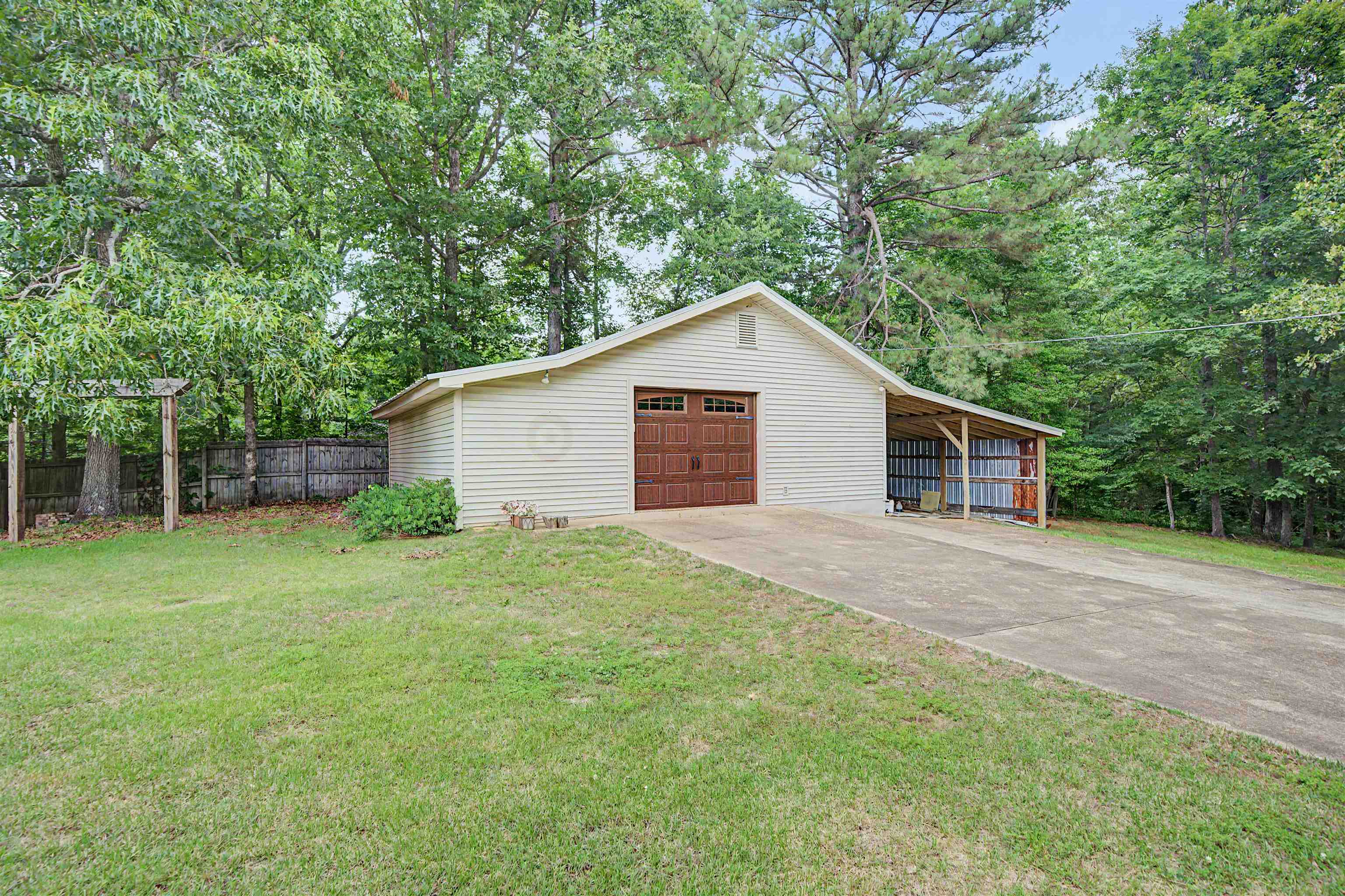 436 Skyline Road Selmer, TN 38375 - Photo 17 of 40 Detached garage with a brown paneled garage door, an attached carport, and a concrete driveway