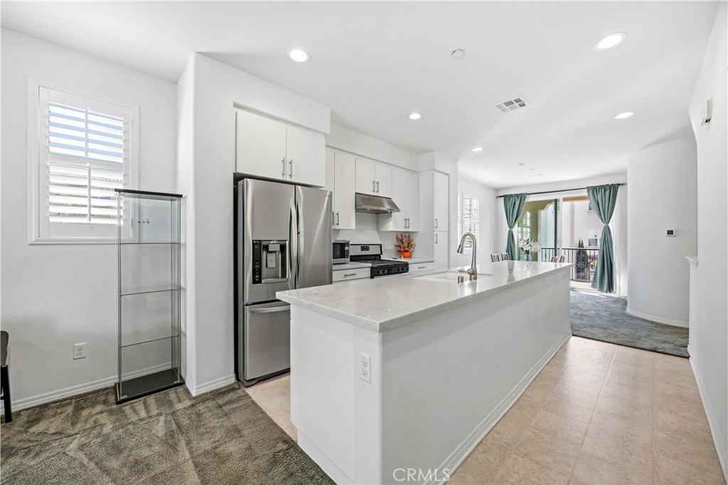 11175 Legion Loop, Unit 110 El Monte, CA 91731 - Photo 8 of 23 a large kitchen with stainless steel appliances granite countertop a refrigerator and a stove