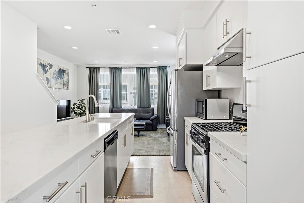11175 Legion Loop, Unit 110 El Monte, CA 91731 - Photo 9 of 23 a kitchen with stainless steel appliances a sink stove and refrigerator