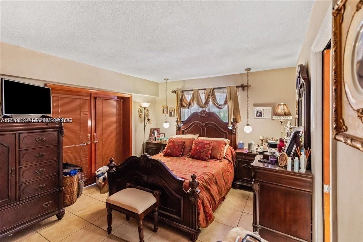 6385 Southwest 25th Street Miami, FL 33155 - Photo 10 of 28 a bedroom with furniture and a flat screen tv