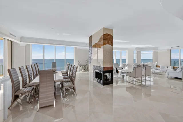 a living room with furniture a fireplace and a dining table with wooden floor