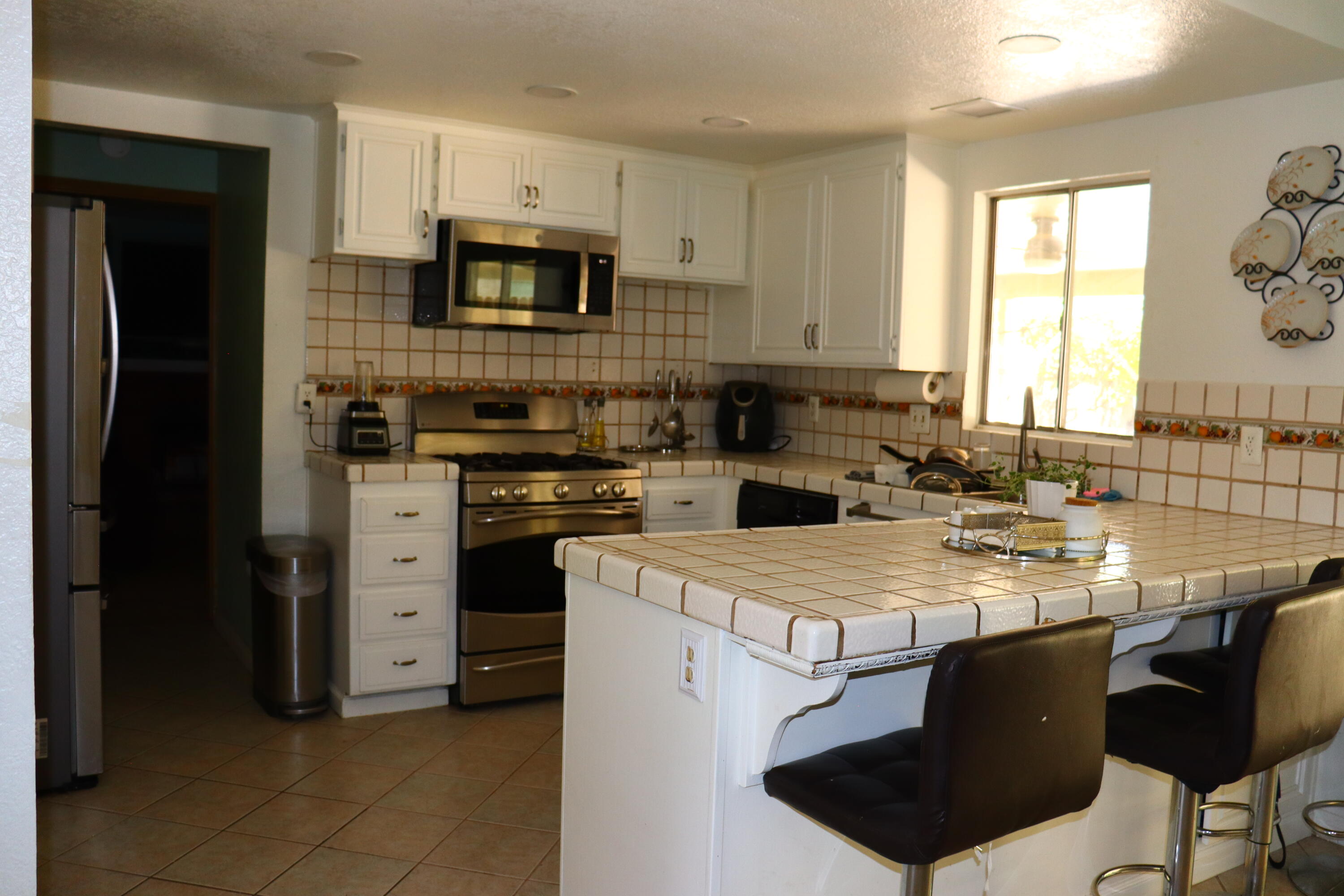 5009 East Ave R 11 Palmdale, CA 93552 - Photo 8 of 23 a kitchen with stainless steel appliances granite countertop a stove a refrigerator a sink a microwave and island