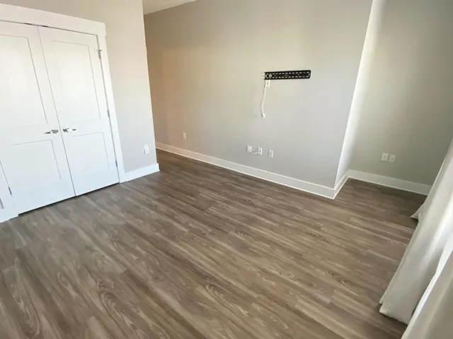 an empty room with wooden floor and closet