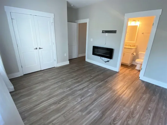 a view of a livingroom with wooden floor and a fireplace