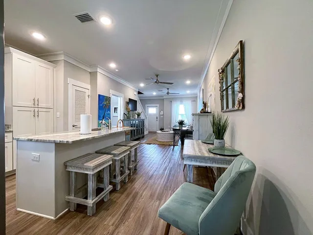 a living room with stainless steel appliances furniture a couch and a kitchen view