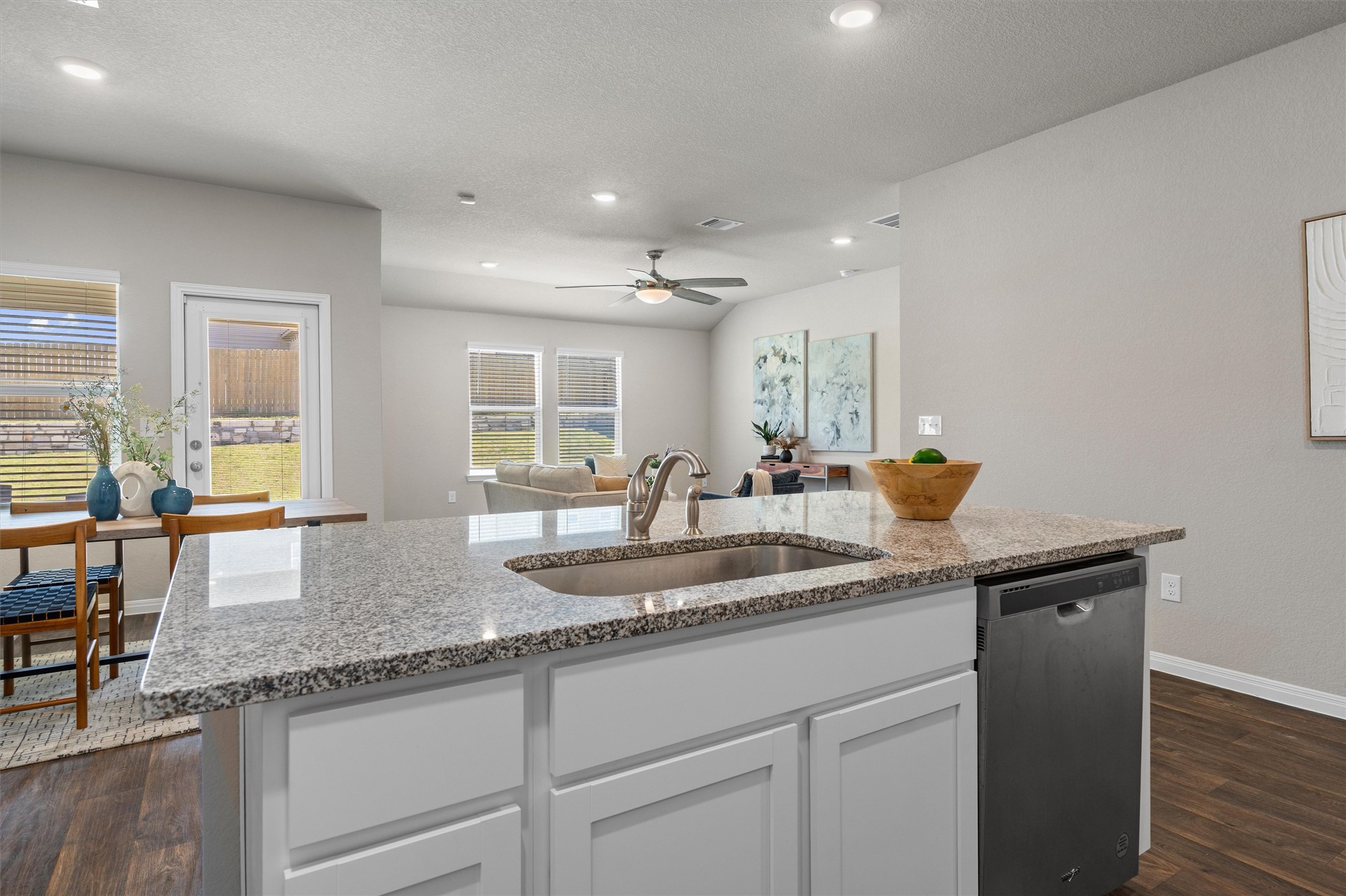 19525 Abigail Fillmore Road Manor, TX 78653 - Photo 11 of 38 A well-lit kitchen island with granite counters and a stainless steel sink defines this open-concept living space.