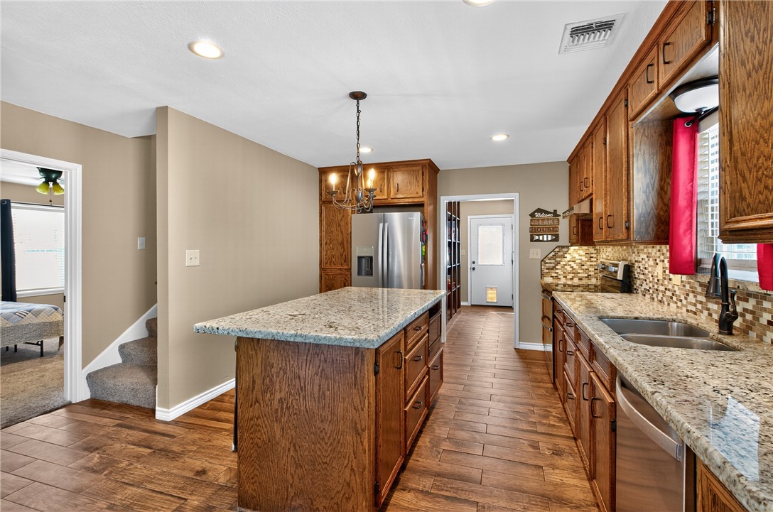 409 Ripple Creek Lane Somerville, TX 77879 - Photo 12 of 33 a kitchen with stainless steel appliances granite countertop plenty wooden cabinets counter space a sink and wooden floor