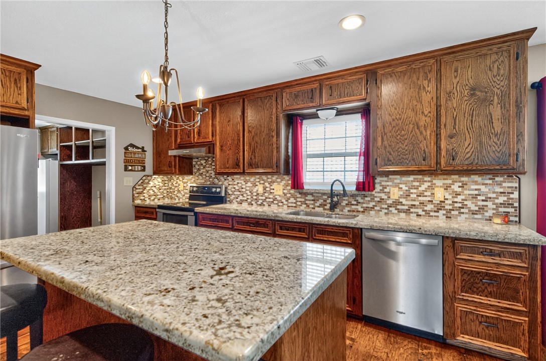 409 Ripple Creek Lane Somerville, TX 77879 - Photo 13 of 33 a kitchen with kitchen island granite countertop wooden cabinets a refrigerator and a sink