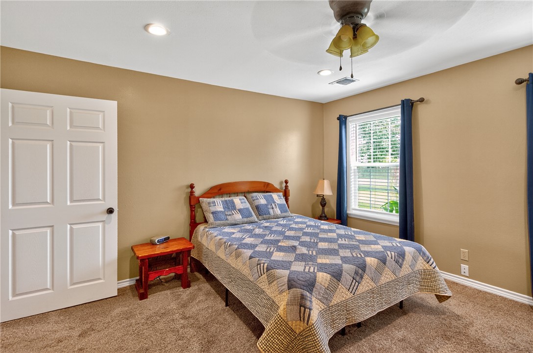 409 Ripple Creek Lane Somerville, TX 77879 - Photo 16 of 33 a bedroom with a bed and a chandelier