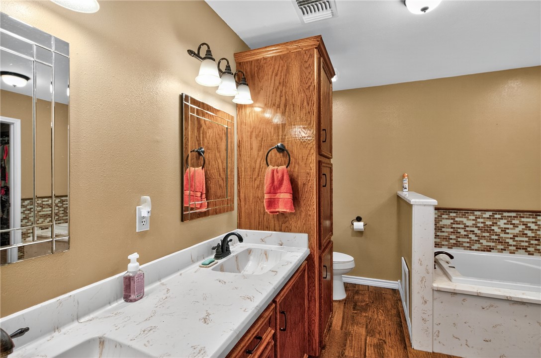 409 Ripple Creek Lane Somerville, TX 77879 - Photo 18 of 33 a bathroom with a granite countertop sink a toilet and shower