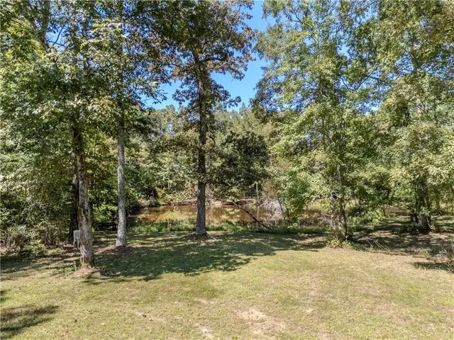 a view of a swimming pool with a lawn chairs under an umbrella
