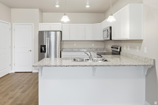 1838 West 300th Street South, Unit B Mapleton, UT 84664 - Photo 16 of 51 Kitchen featuring white cabinetry, light-toned countertops, stainless steel appliances, and pendant lighting