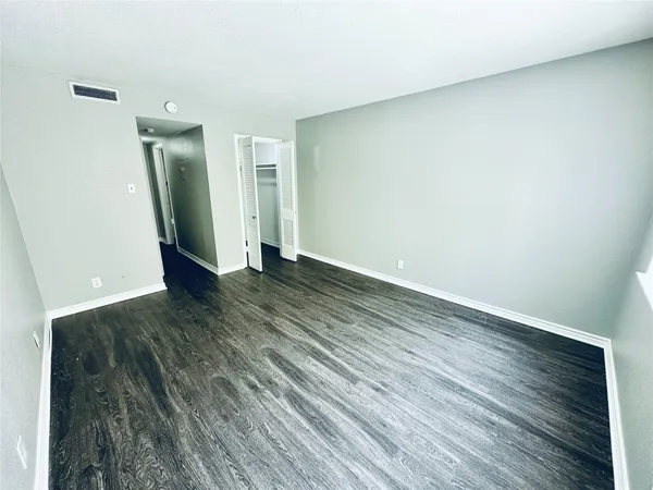 an empty room with wooden floor and a mirror