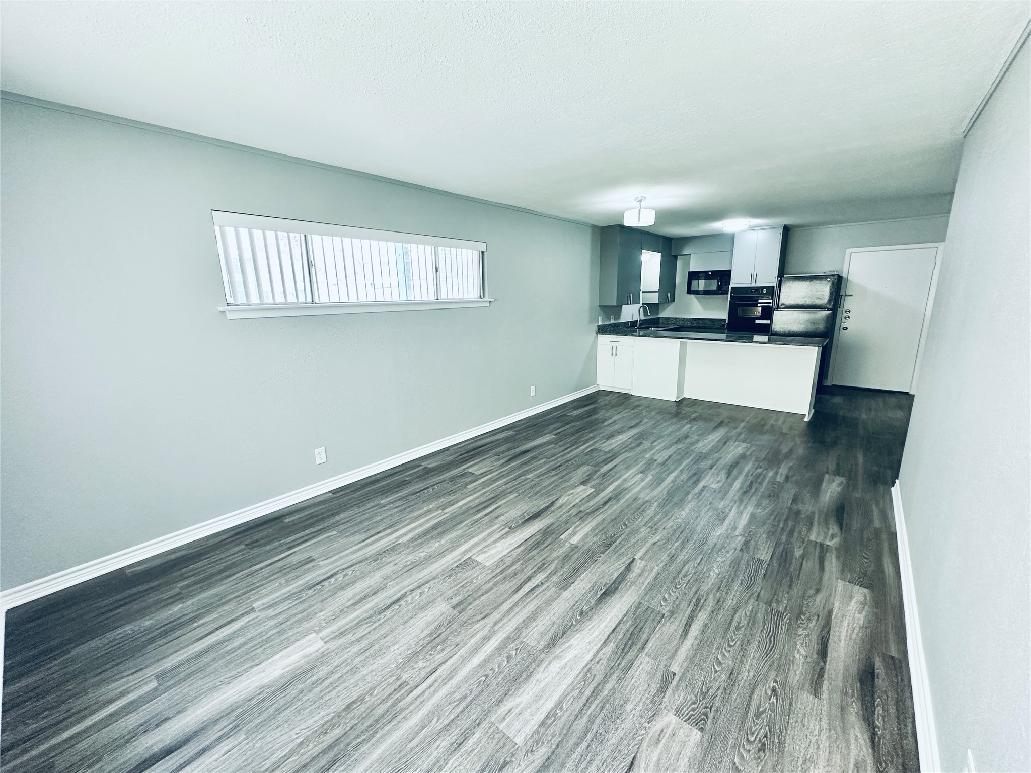 601 West 11th Street, Unit 121 Austin, TX 78701 - Photo 4 of 7 a view of kitchen and empty room with wooden floor