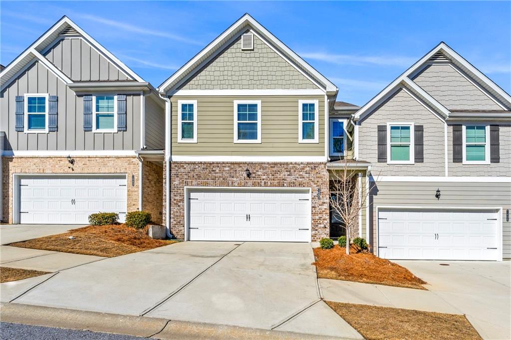 7492 Knoll Hollow Road Lithonia, GA 30058 - Photo 1 of 30 a front view of a house with a yard and garage