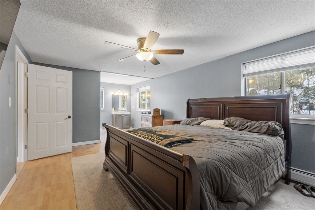 60 Stone Valley Road Orange, MA 01364 - Photo 14 of 27 a bedroom with a bed and a chandelier